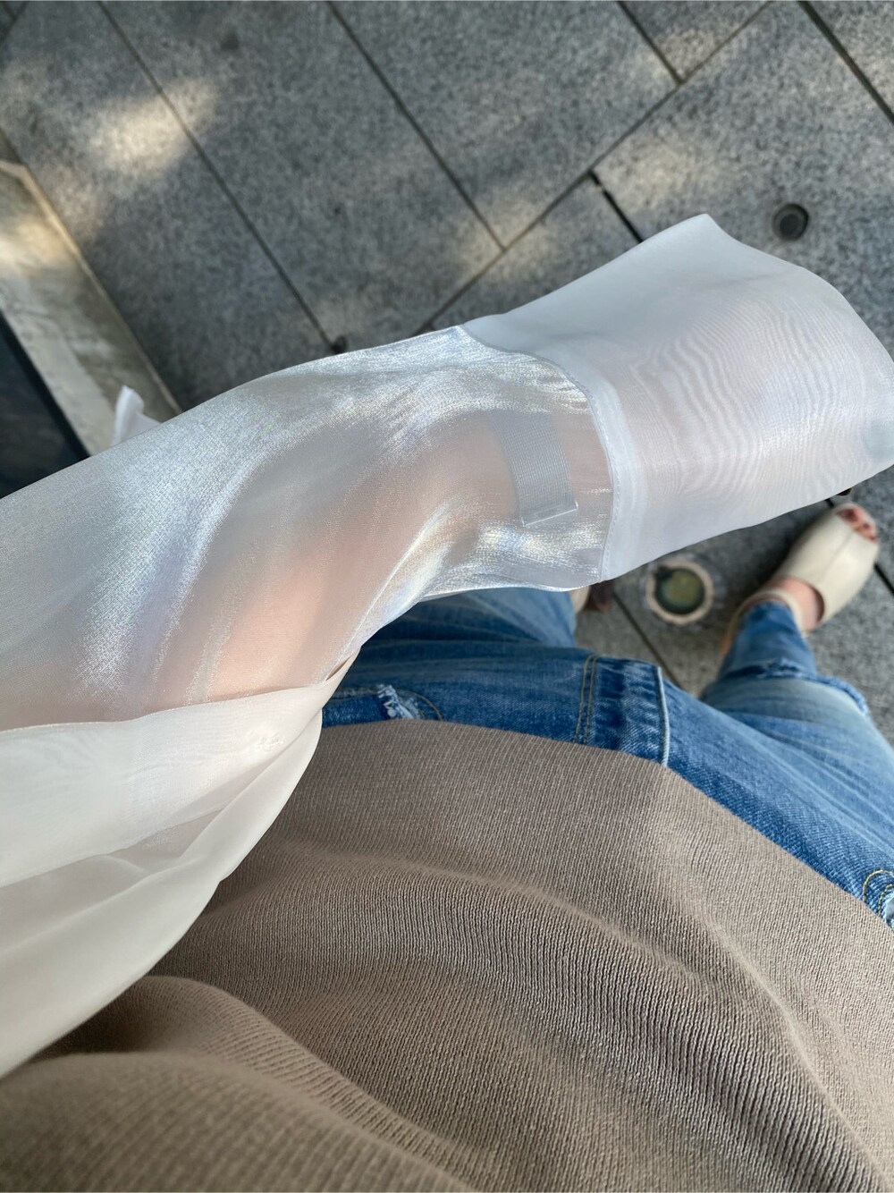 ホワイト系のサンダル、ブルー系のデニムパンツ、ベージュ系のニット/セーターを着用したレディースの春コーディネートの6枚目の写真