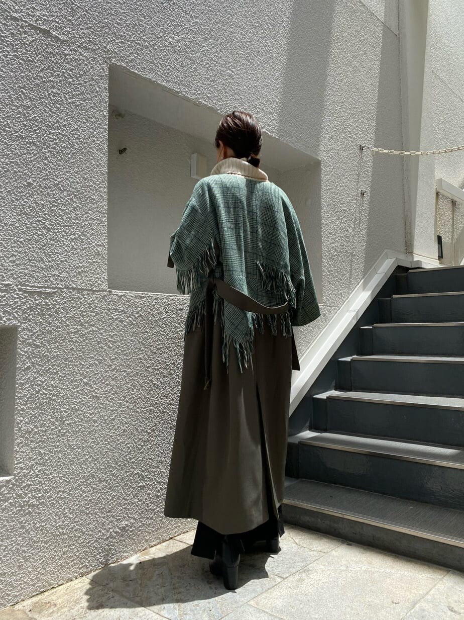 ベージュ系のトレンチコートを着用したレディースの夏コーディネートの4枚目の写真