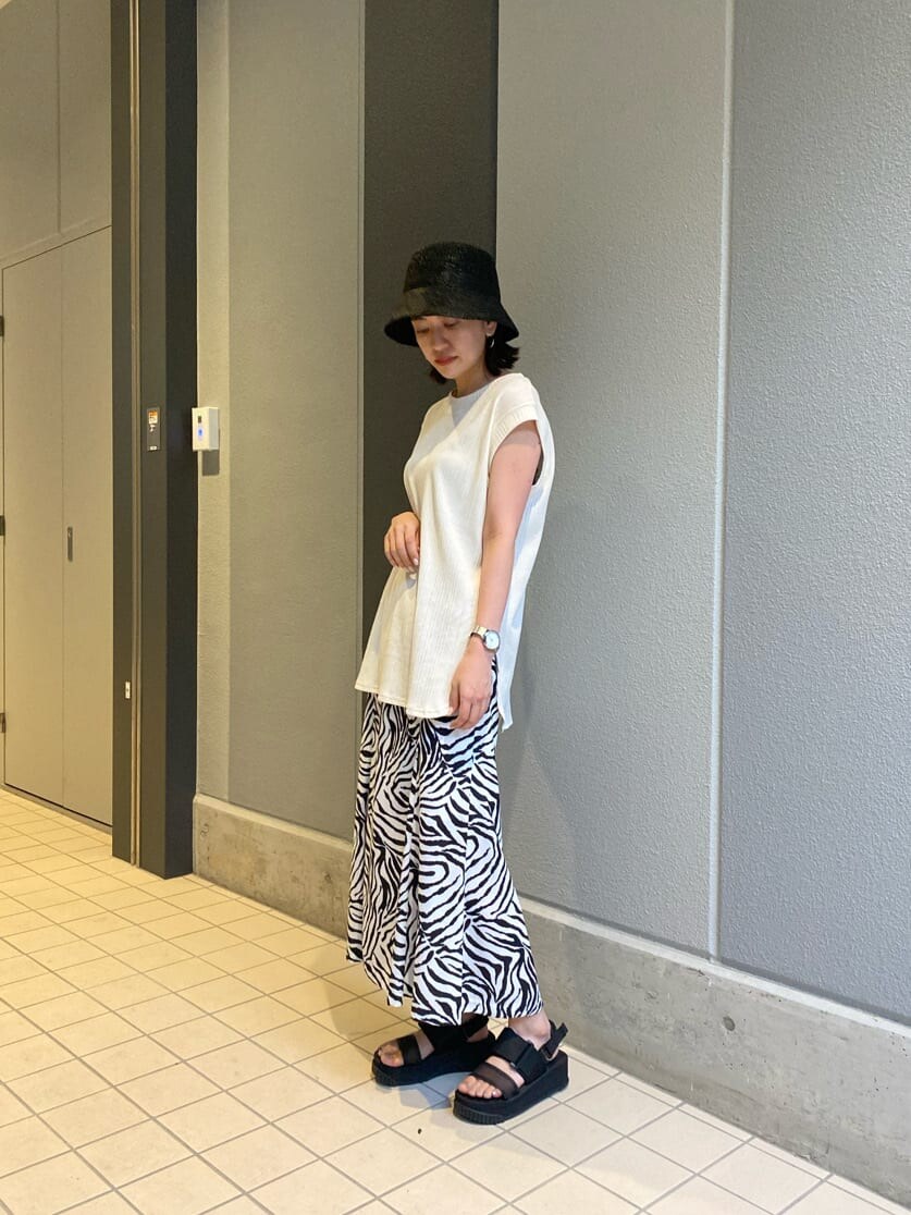 ブラック系のサンダル、その他のスカート、ホワイト系のTシャツ/カットソーを着用したレディースの夏コーディネートの2枚目の写真