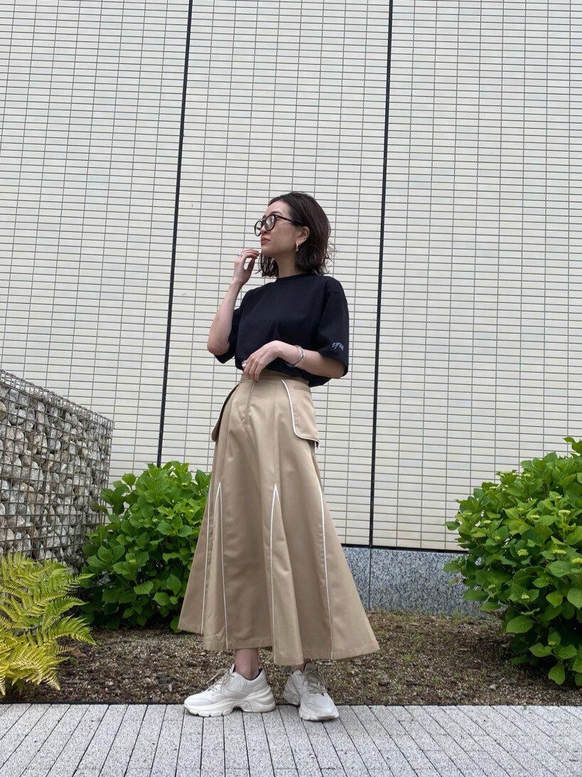 ベージュ系のスカート、ブラック系のTシャツ/カットソーを着用したレディースの春コーディネートの4枚目の写真