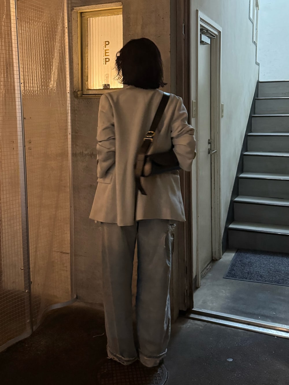 グリーン系のテーラードジャケットを着用したレディースの春コーディネートの3枚目の写真