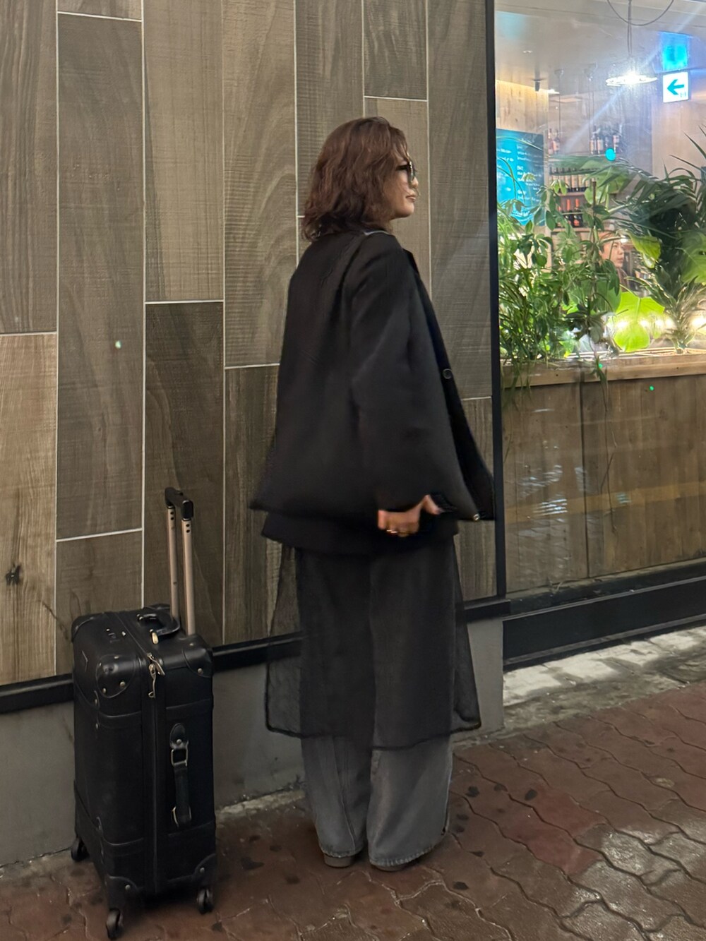 ブラック系のテーラードジャケット、ブラック系のデニムパンツ、ブラック系のストール/ショールを着用したレディースの春コーディネートの2枚目の写真