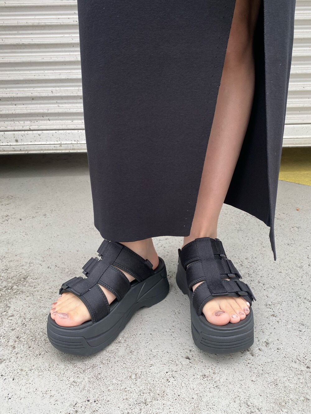 グレー系のテーラードジャケット、ブラック系のタンクトップ、ブラック系のスカートを着用したレディースの春コーディネートの5枚目の写真