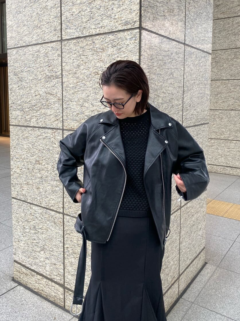 ブラック系のライダースジャケット、ブラック系のスカート、ブラック系のブーツを着用したレディースの冬コーディネートの6枚目の写真