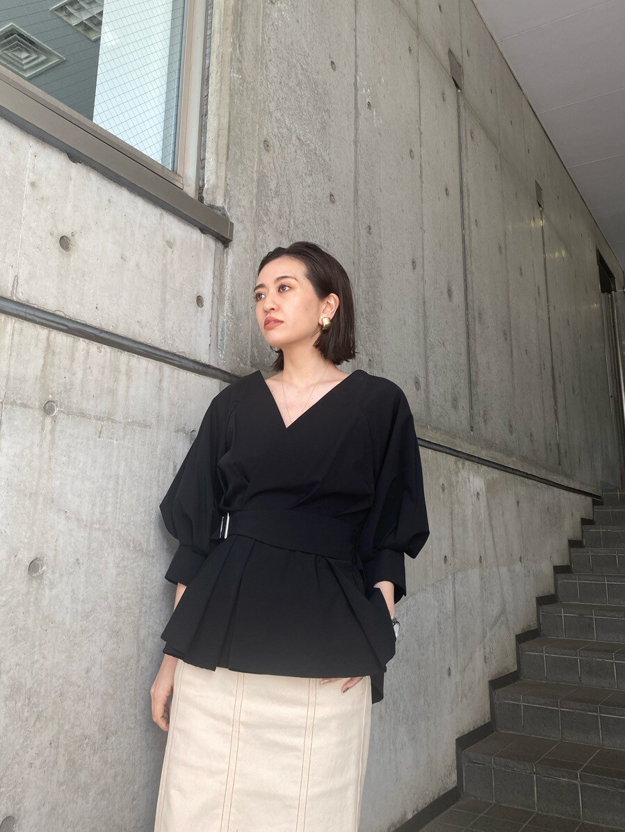ブラック系のシャツ/ブラウス、ブラック系のパンプス、ホワイト系のスカートを着用したレディースの春コーディネートの4枚目の写真