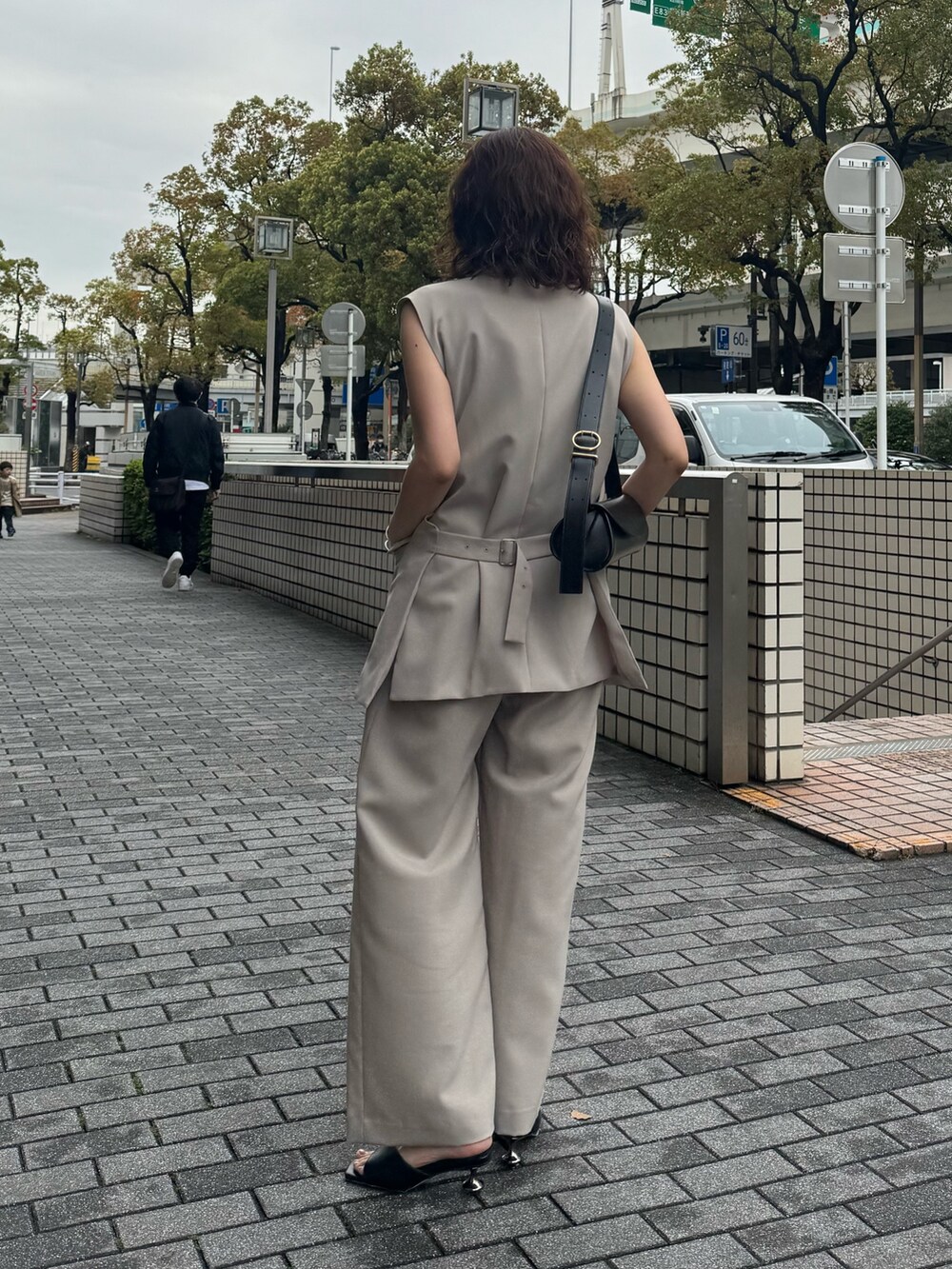ベージュ系のその他パンツ、ベージュ系のベスト、ブラック系のサンダルを着用したレディースの春コーディネートの3枚目の写真