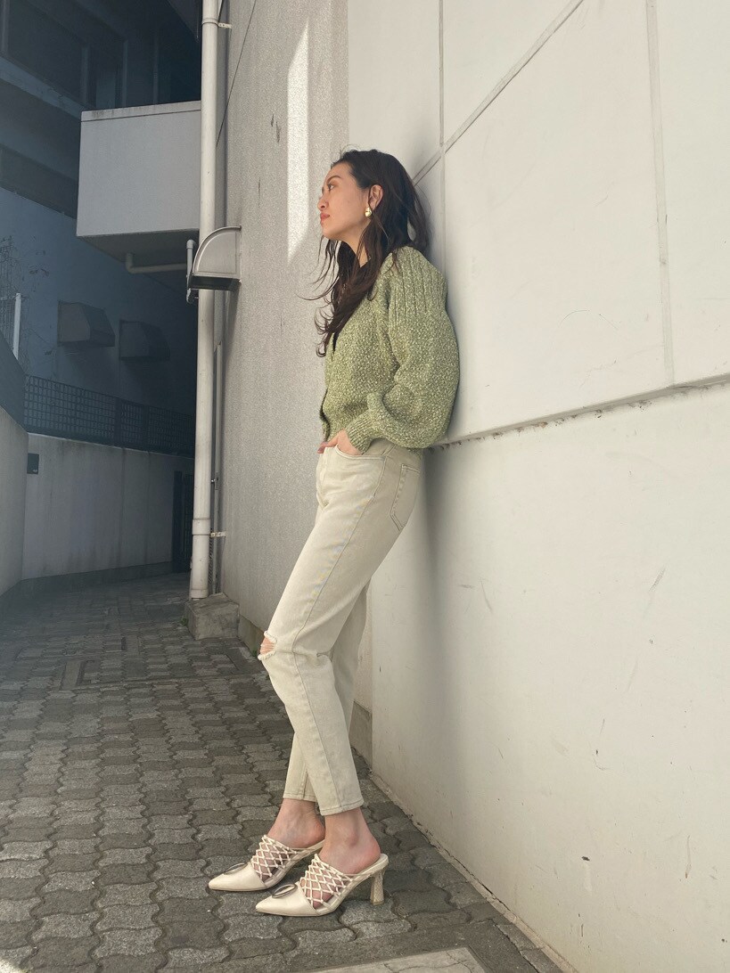 グリーン系のカーディガン/ボレロ、ホワイト系のパンプス、ゴールド系のイヤリングを着用したレディースの冬コーディネートの4枚目の写真