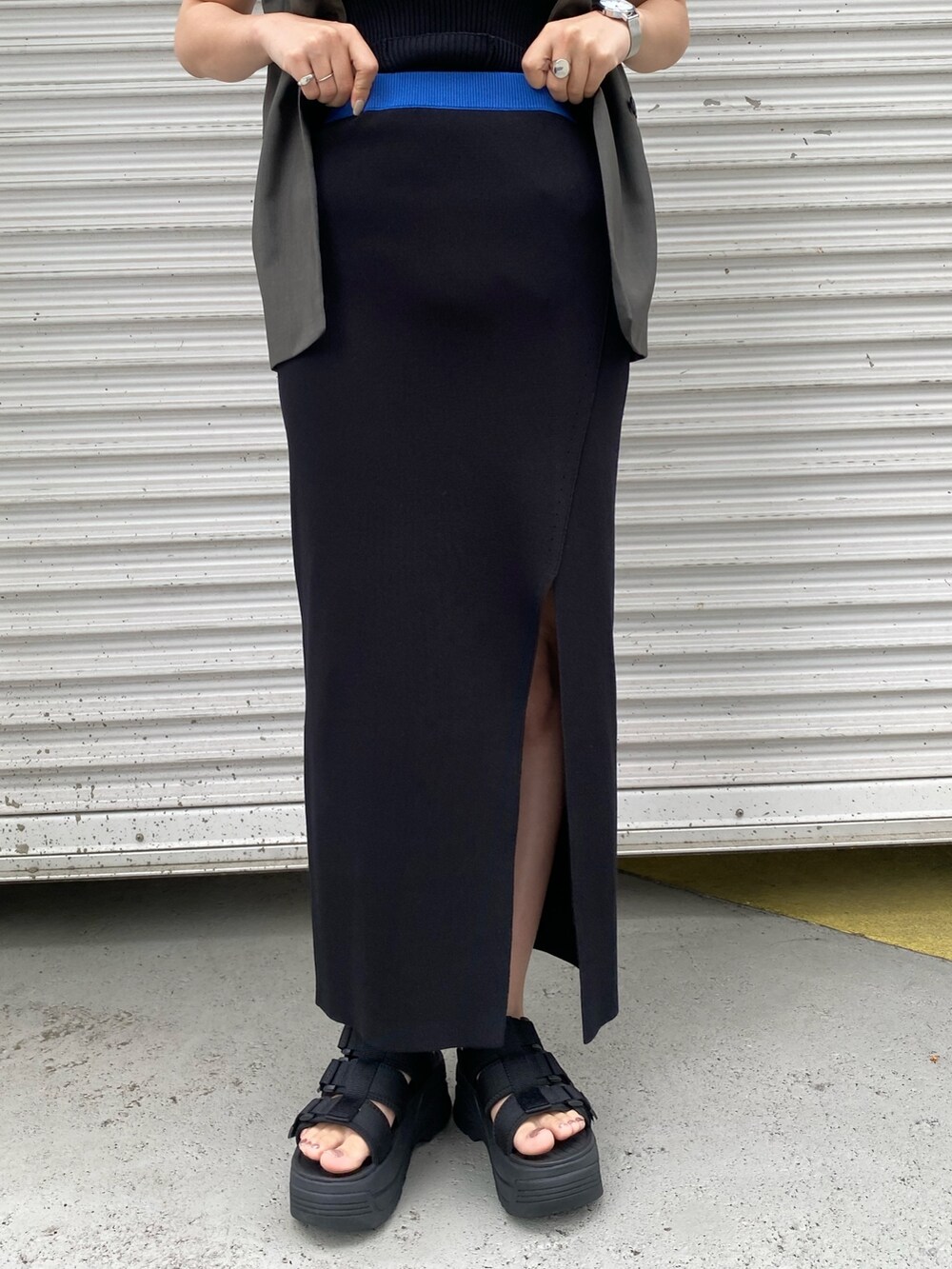 グレー系のテーラードジャケット、ブラック系のタンクトップ、ブラック系のスカートを着用したレディースの春コーディネートの4枚目の写真