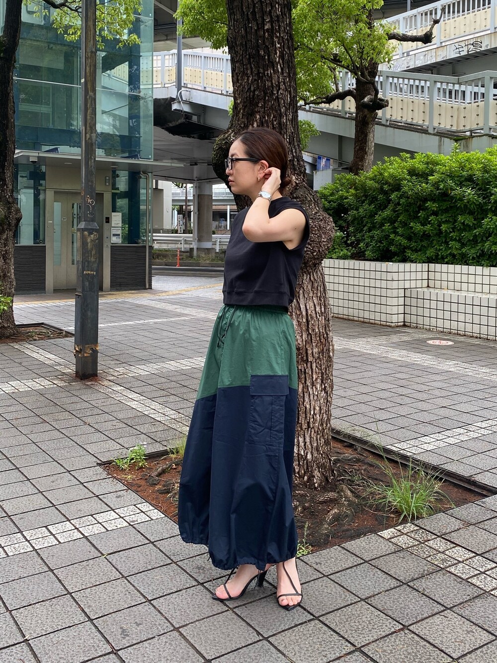 ブルー系のスカート、ブラック系のタンクトップを着用したレディースの夏コーディネートの3枚目の写真