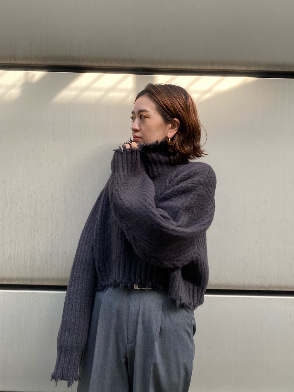 グレー系のチェスターコート、グレー系のニット/セーターを着用したレディースの秋コーディネートの5枚目の写真