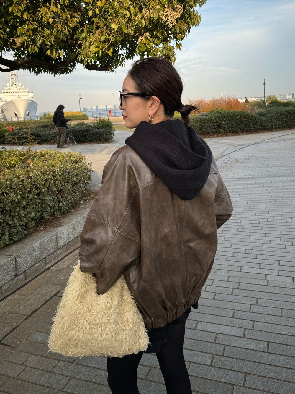 ブラウン系のブルゾン、ブラック系のブーツを着用したレディースの冬コーディネートの6枚目の写真