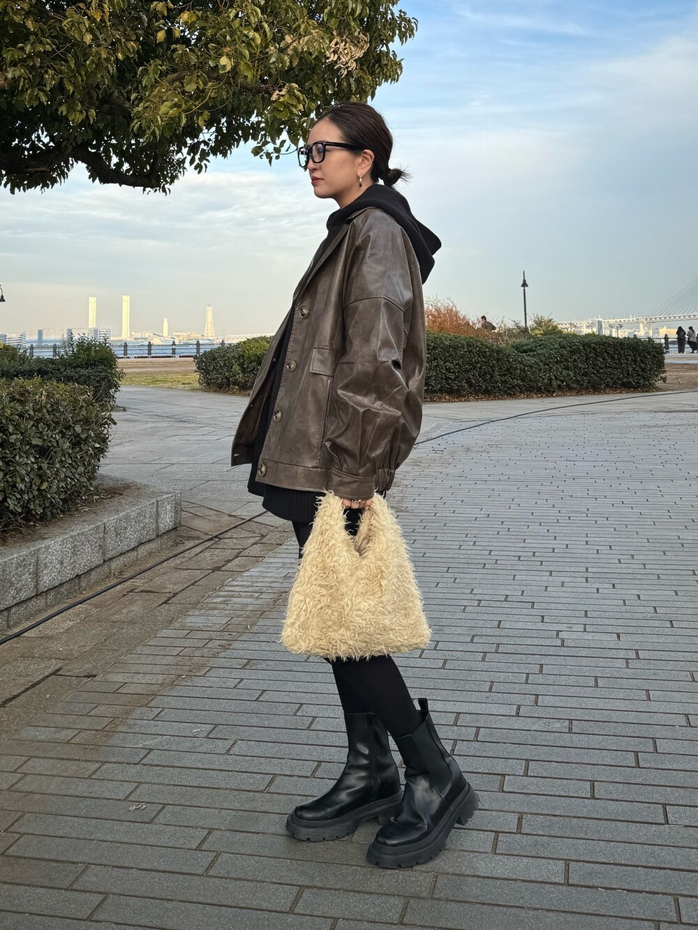 ブラウン系のブルゾン、ブラック系のブーツを着用したレディースの冬コーディネートの3枚目の写真