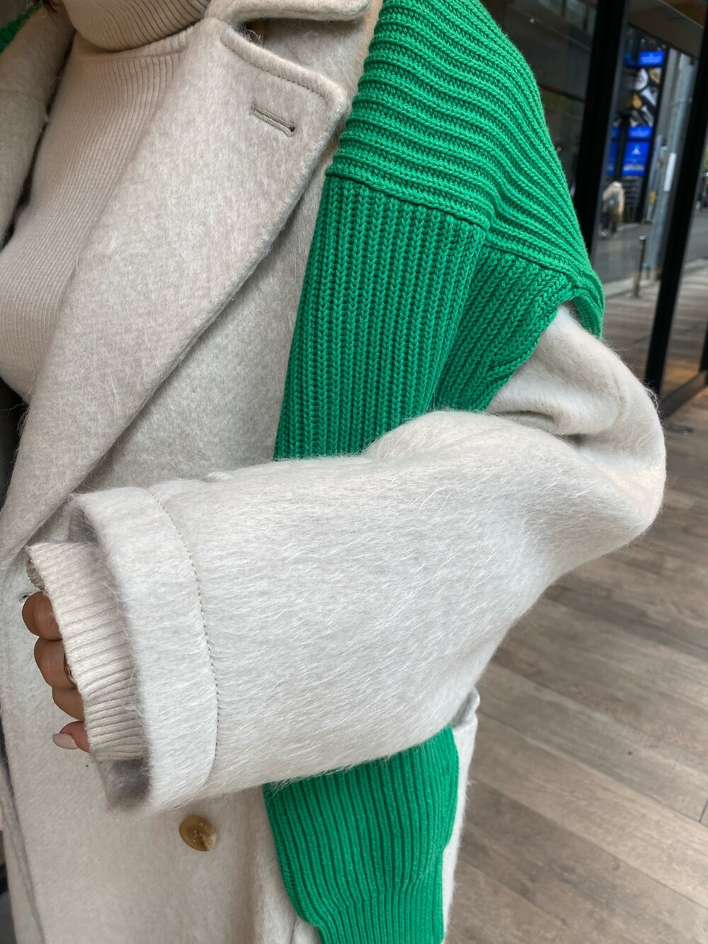 グリーン系のニット/セーター、ホワイト系のチェスターコート、ホワイト系のニット/セーターを着用したレディースの冬コーディネートの6枚目の写真