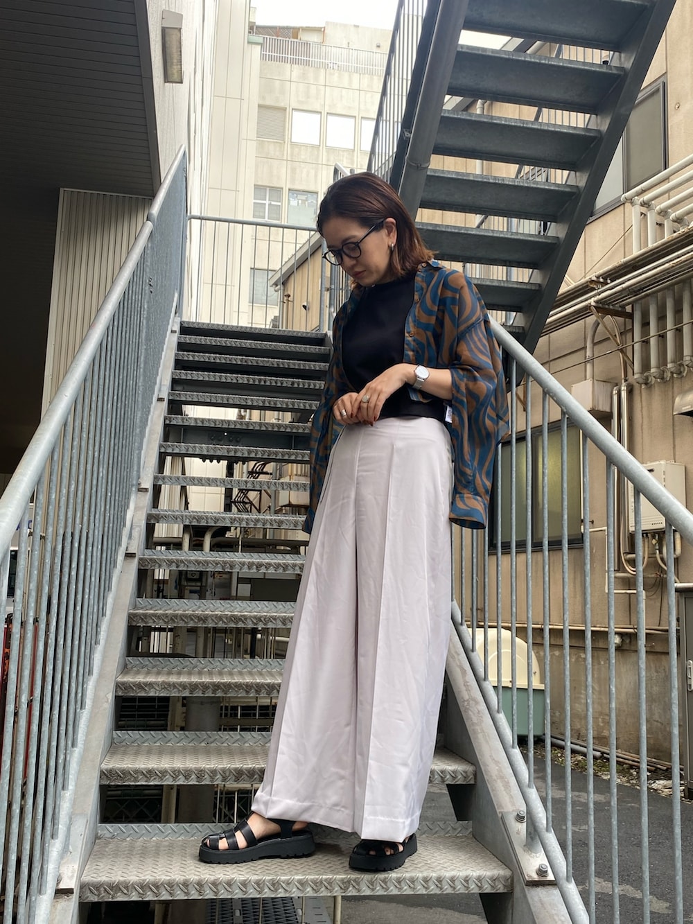 グレー系のその他パンツ、ブルー系のシャツ/ブラウス、ブラック系のタンクトップを着用したレディースの夏コーディネートの4枚目の写真