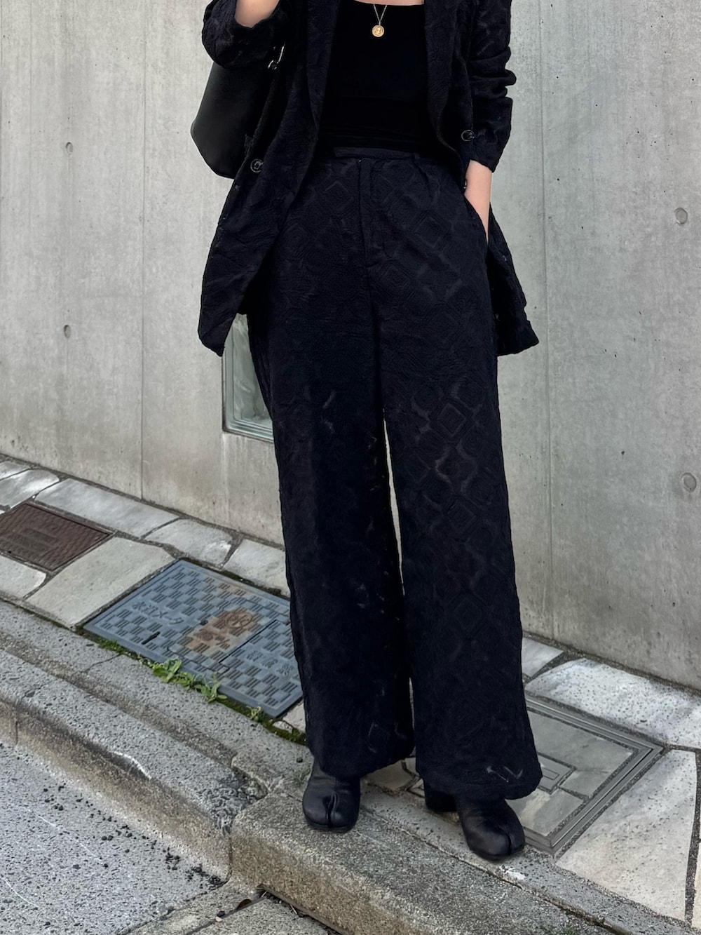 ブラック系のテーラードジャケット、ブラック系のその他パンツを着用したレディースの春コーディネートの3枚目の写真