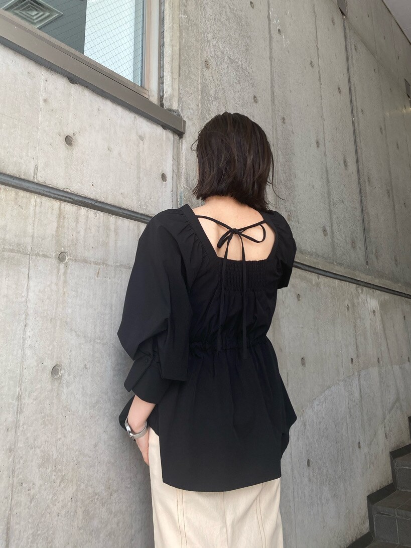 ブラック系のシャツ/ブラウス、ブラック系のパンプス、ホワイト系のスカートを着用したレディースの春コーディネートの2枚目の写真