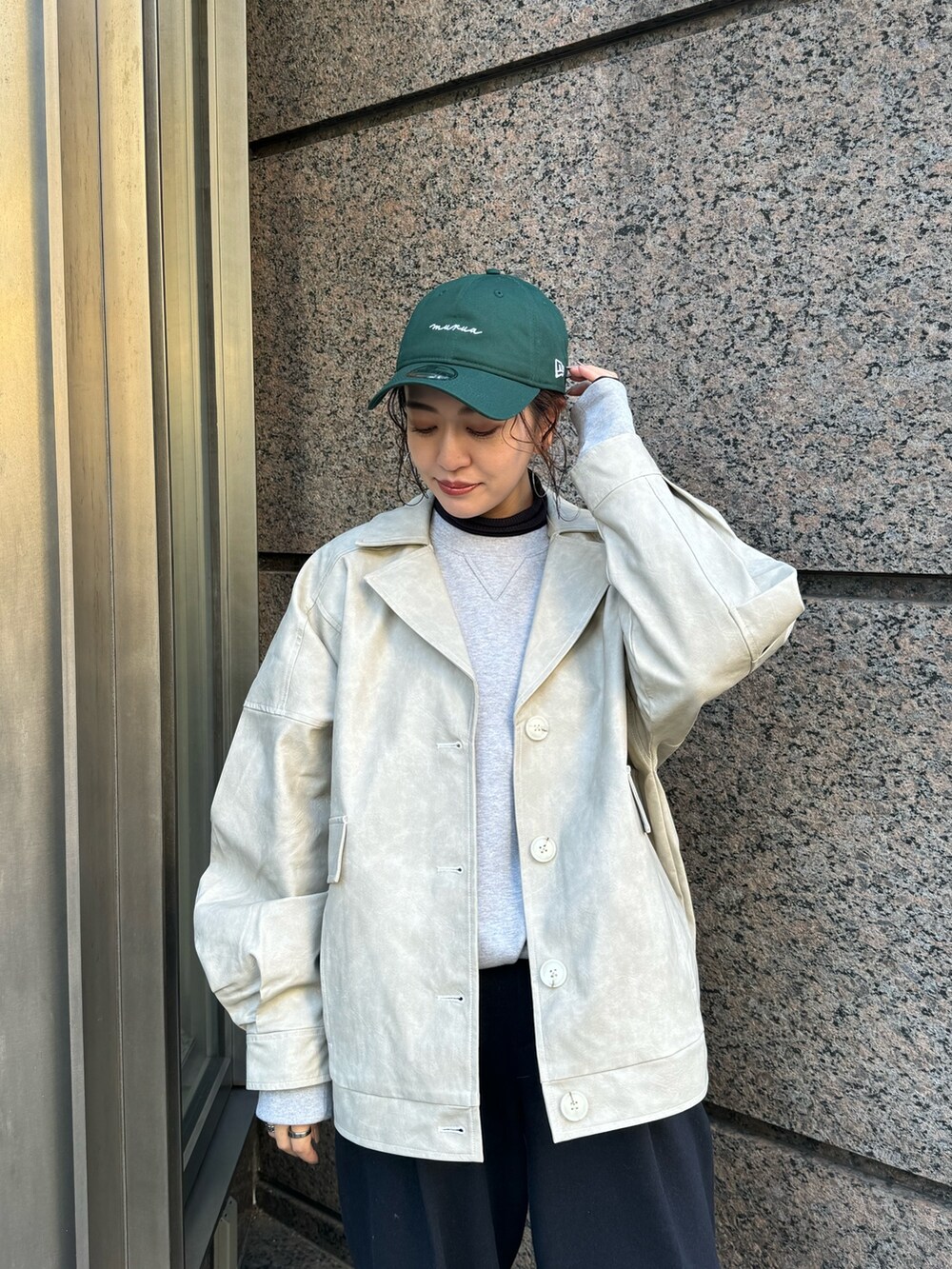 ホワイト系のブルゾン、グリーン系のキャップを着用したレディースの冬コーディネートの5枚目の写真