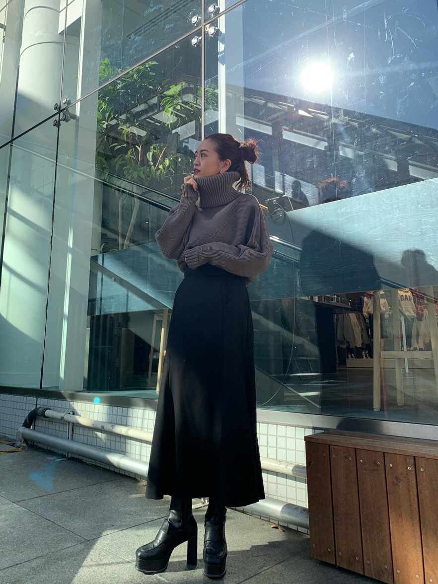 ブラック系のブーツ、ブラック系のスカート、ベージュ系のニット/セーターを着用したレディースの冬コーディネートの3枚目の写真