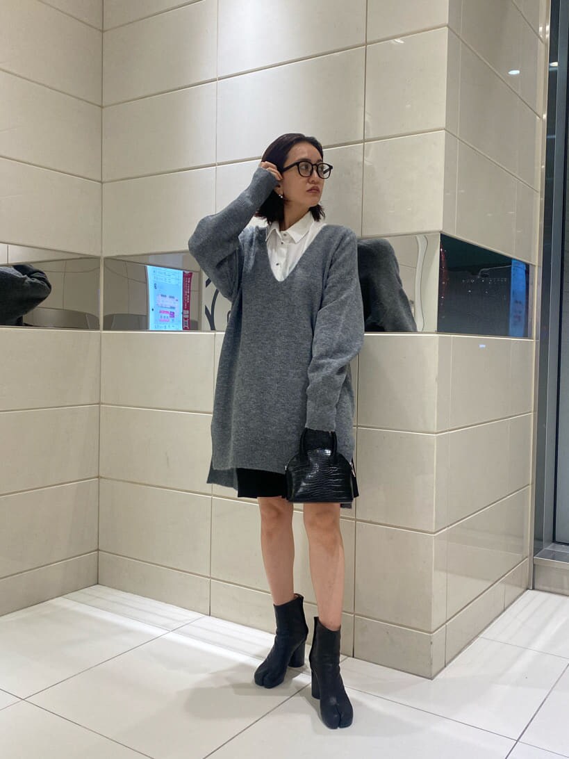 ブラック系のハンドバッグ、グレー系のニット/セーターを着用したレディースの秋コーディネートの3枚目の写真