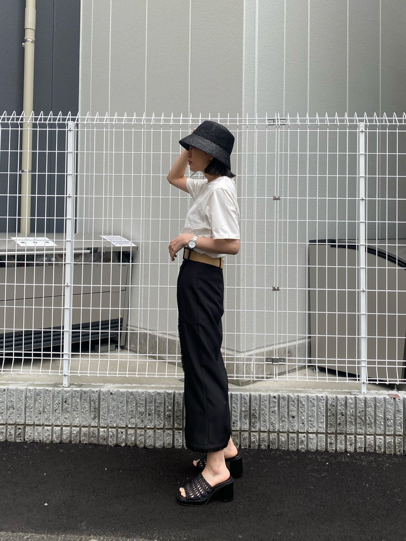 ブラック系のスカート、ブラック系のサンダル、ホワイト系のTシャツ/カットソーを着用したレディースの春コーディネートの3枚目の写真