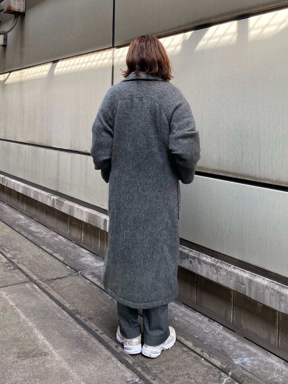 グレー系のチェスターコート、グレー系のニット/セーターを着用したレディースの秋コーディネートの4枚目の写真