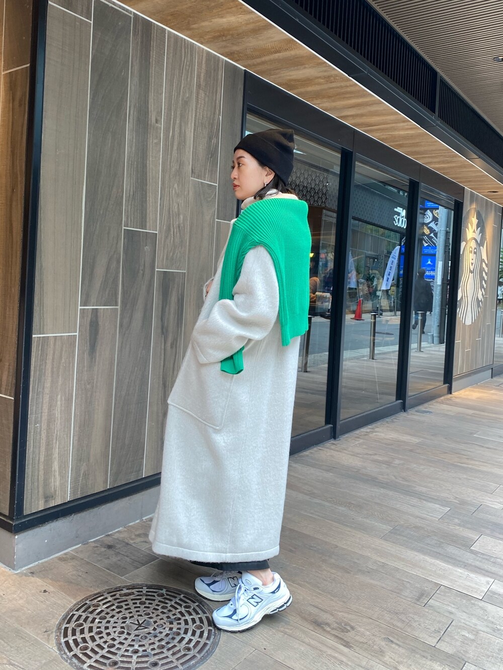 グリーン系のニット/セーター、ホワイト系のチェスターコート、ホワイト系のニット/セーターを着用したレディースの冬コーディネートの4枚目の写真