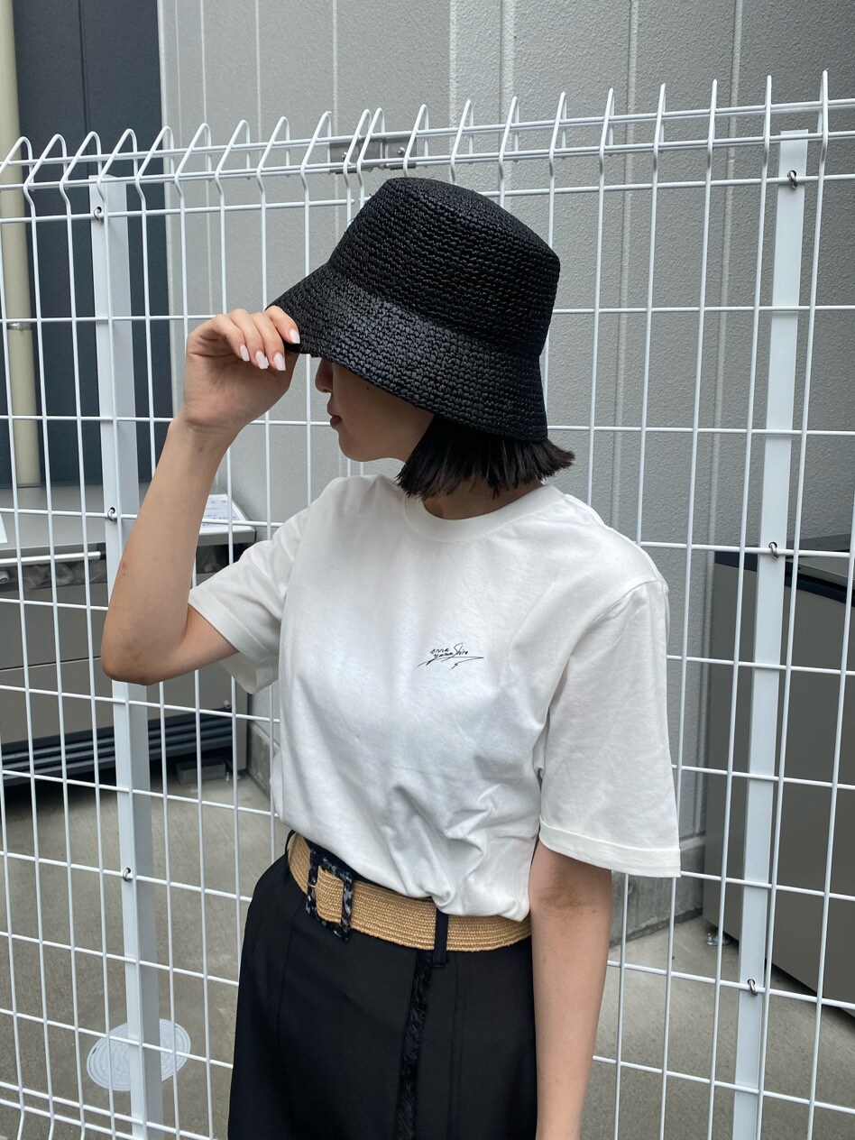 ブラック系のスカート、ブラック系のサンダル、ホワイト系のTシャツ/カットソーを着用したレディースの春コーディネートの6枚目の写真