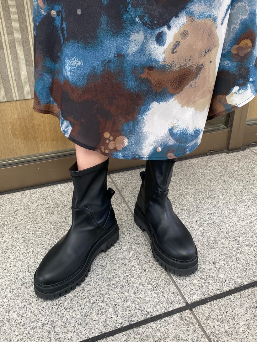 ブルー系のスカート、ブラック系のブーツ、ホワイト系のパーカーを着用したレディースの秋コーディネートの9枚目の写真