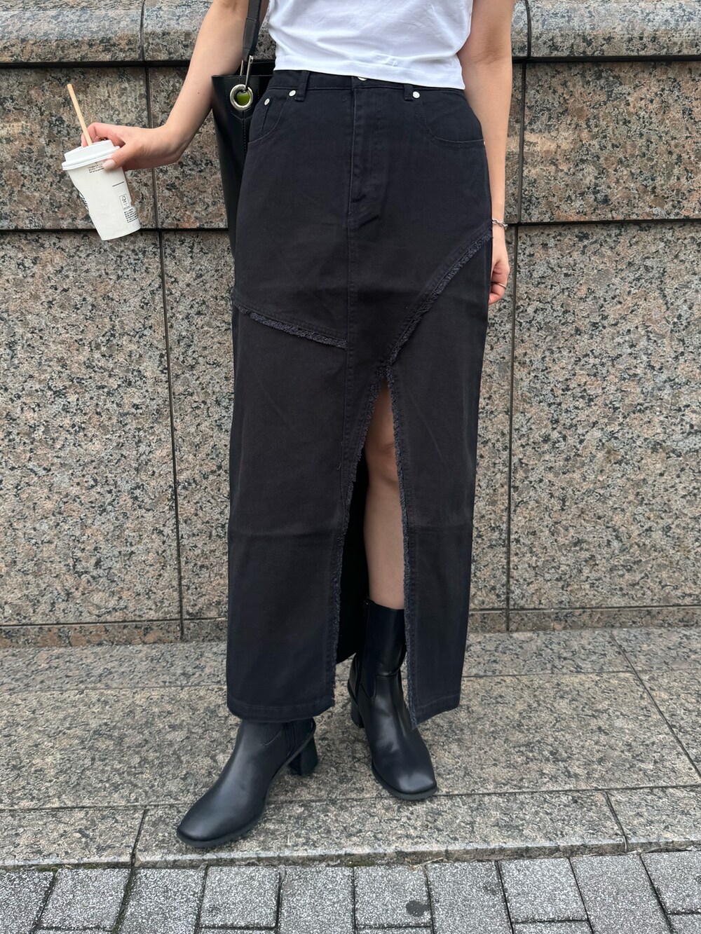 ブラック系のデニムスカート、ブラック系のブーツを着用したレディースの夏コーディネートの5枚目の写真