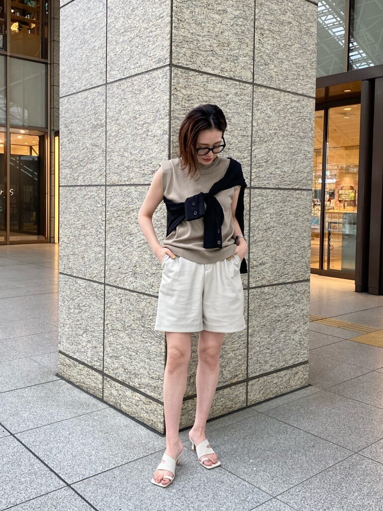 ホワイト系のサンダル、ブラック系のシャツ/ブラウス、ベージュ系のタンクトップを着用したレディースの春コーディネートの2枚目の写真