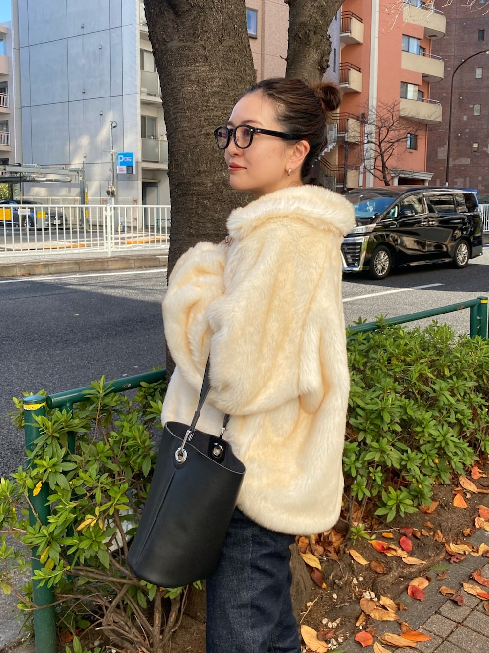 ホワイト系のブルゾン、ブルー系のデニムパンツを着用したレディースの冬コーディネートの5枚目の写真