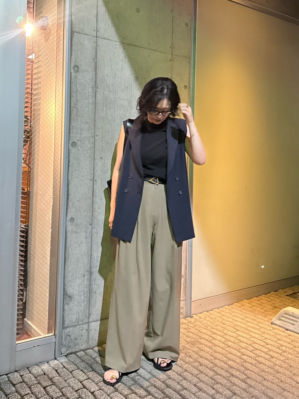 ブルー系のベストを着用したレディースの夏コーディネートの2枚目の写真