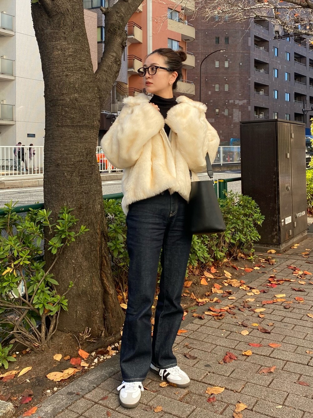 ホワイト系のブルゾン、ブルー系のデニムパンツを着用したレディースの冬コーディネートの2枚目の写真