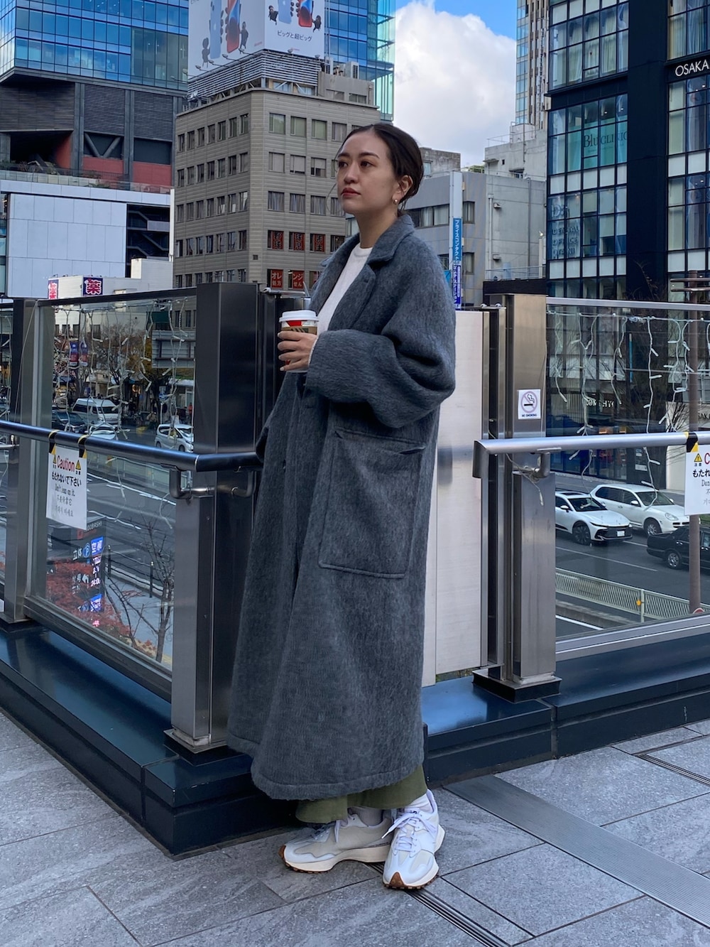 グレー系のチェスターコート、ホワイト系のニット/セーター、ベージュ系のスカートを着用したレディースの冬コーディネートの4枚目の写真