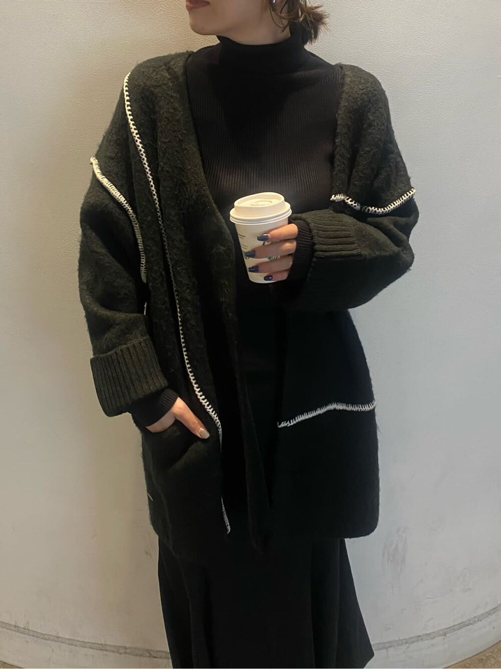 ブラック系のニット/セーター、ブラック系のスカート、ブラック系のカーディガン/ボレロを着用したレディースの冬コーディネートの5枚目の写真