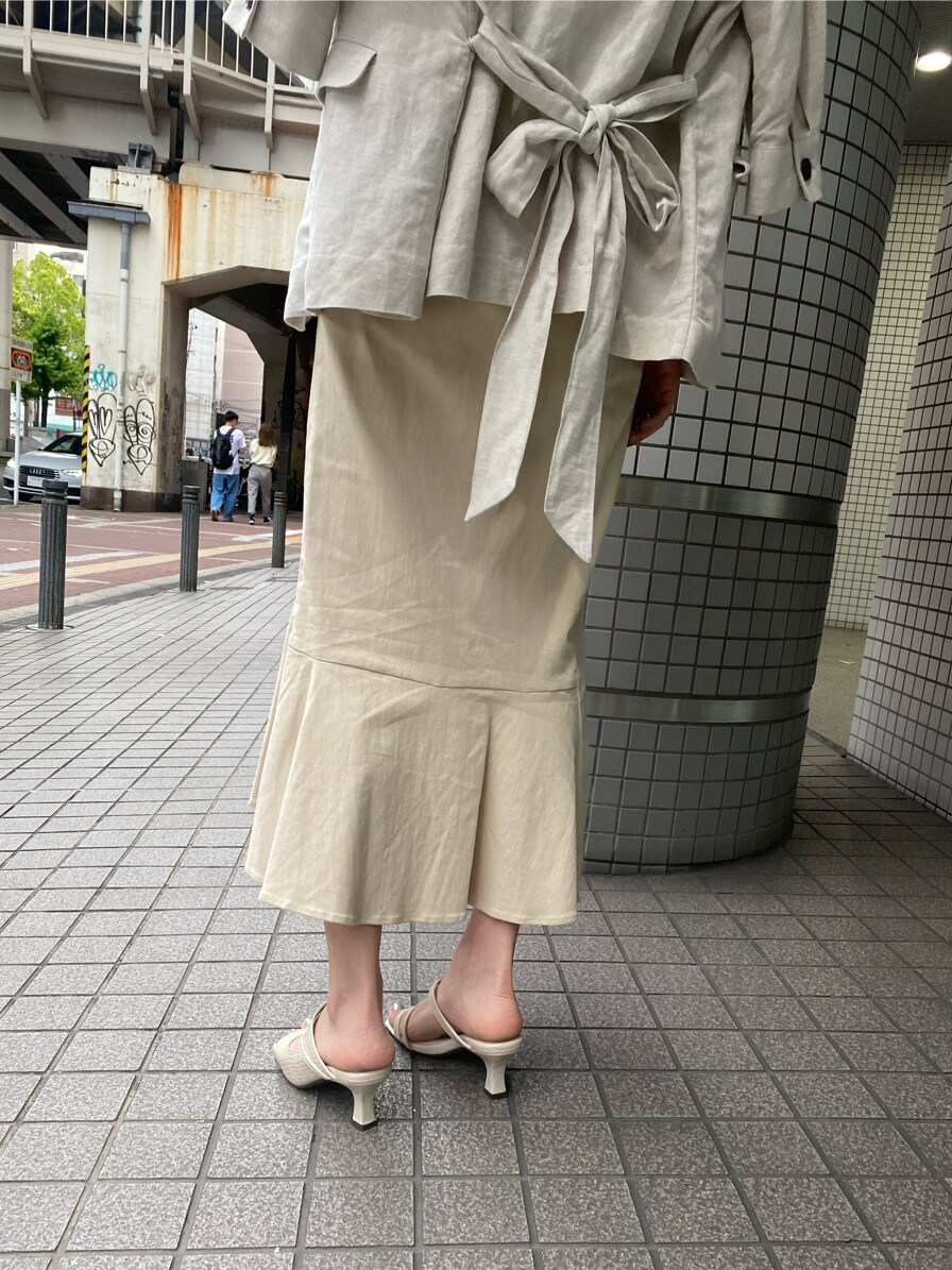 ホワイト系のサンダル、ホワイト系のスカート、グリーン系のニット/セーターを着用したレディースの春コーディネートの6枚目の写真