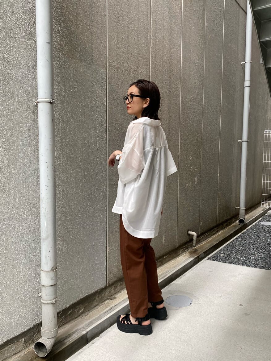 ホワイト系のシャツ/ブラウス、ブラック系のサンダル、ブラック系のTシャツ/カットソーを着用したレディースの夏コーディネートの2枚目の写真