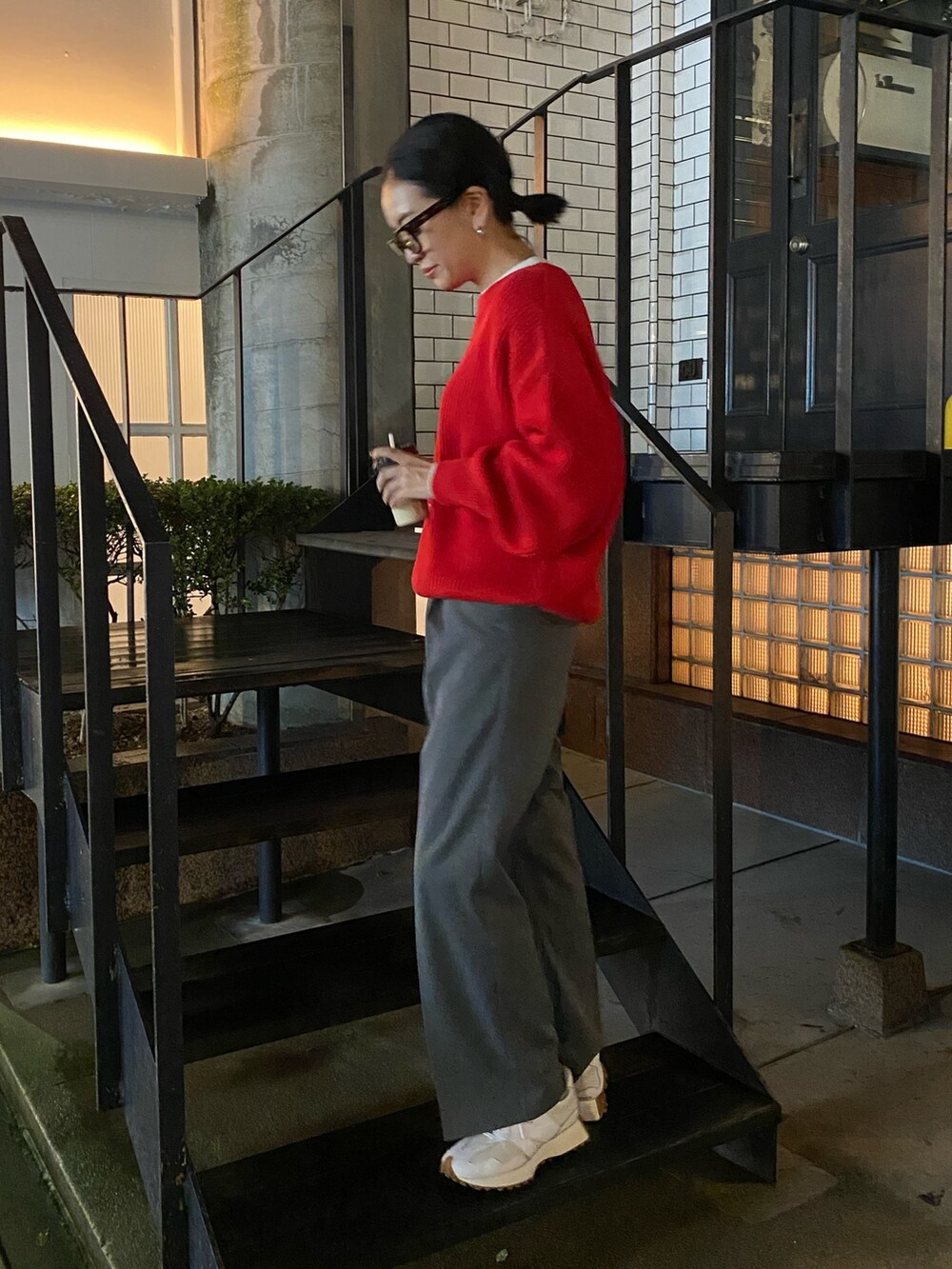 グレー系のスラックス、レッド系のニット/セーターを着用したレディースの秋コーディネートの5枚目の写真