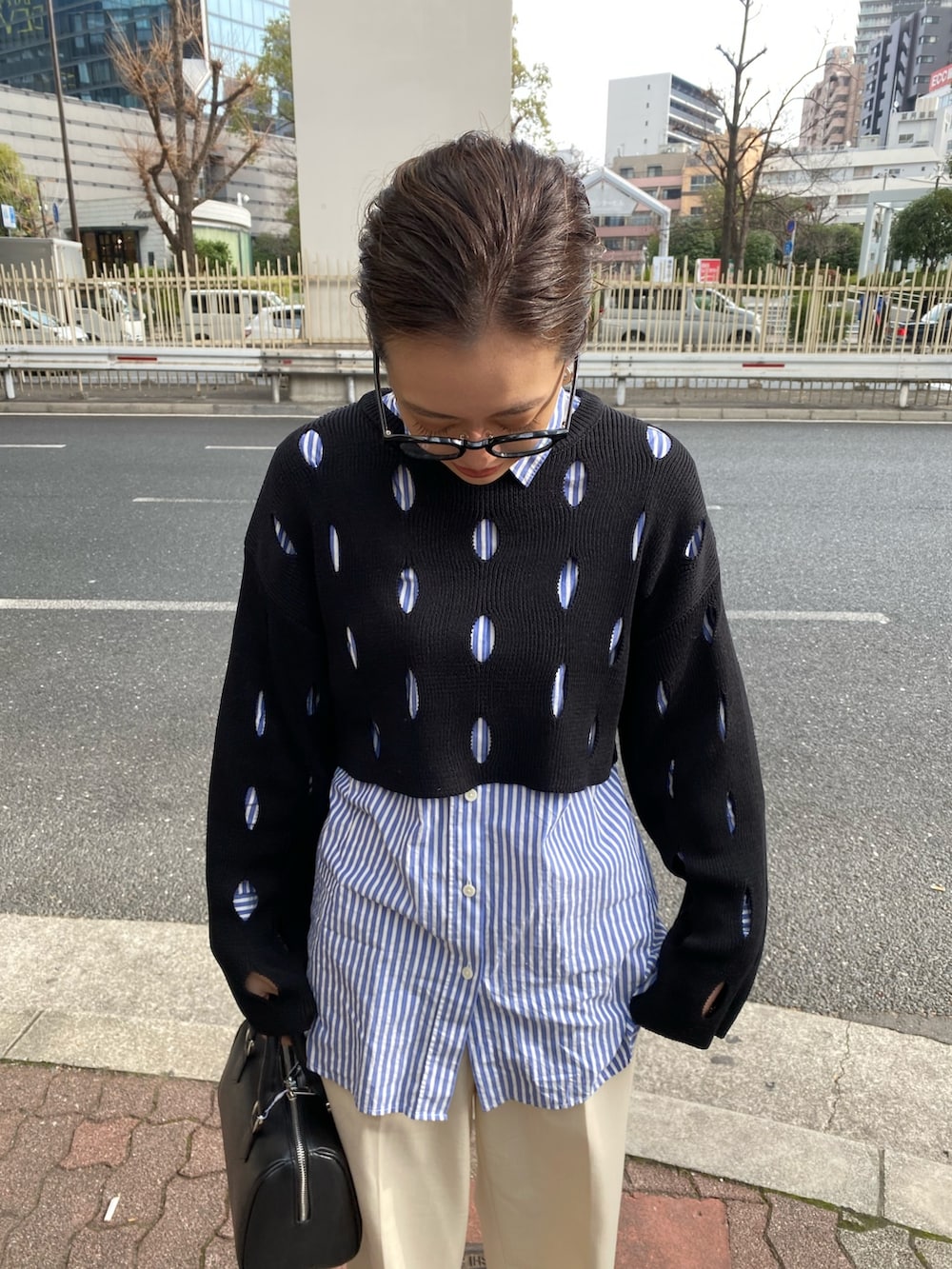 ブラック系のニット/セーター、ブラック系のハンドバッグを着用したレディースの冬コーディネートの5枚目の写真