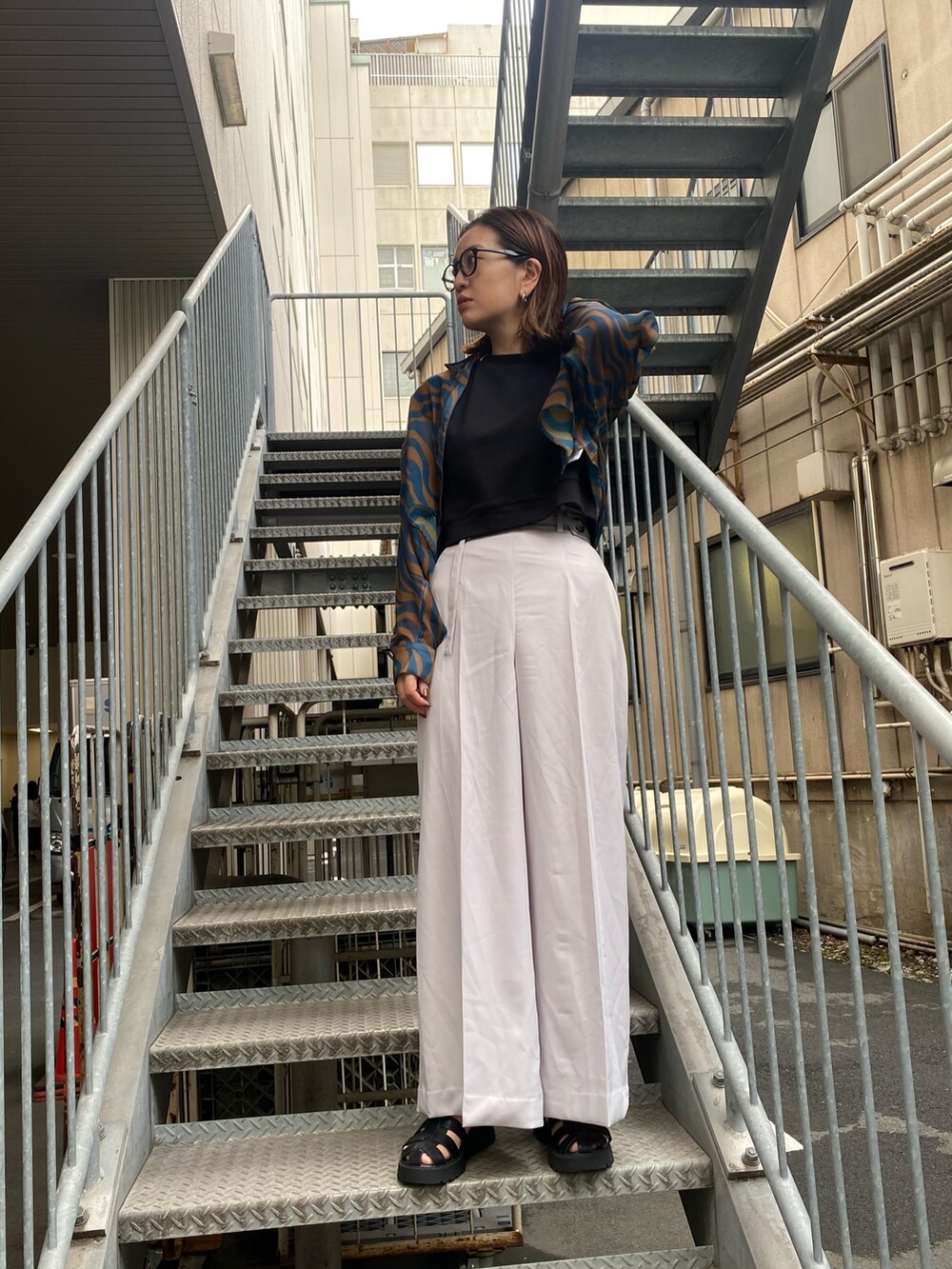 グレー系のその他パンツ、ブルー系のシャツ/ブラウス、ブラック系のタンクトップを着用したレディースの夏コーディネートの2枚目の写真