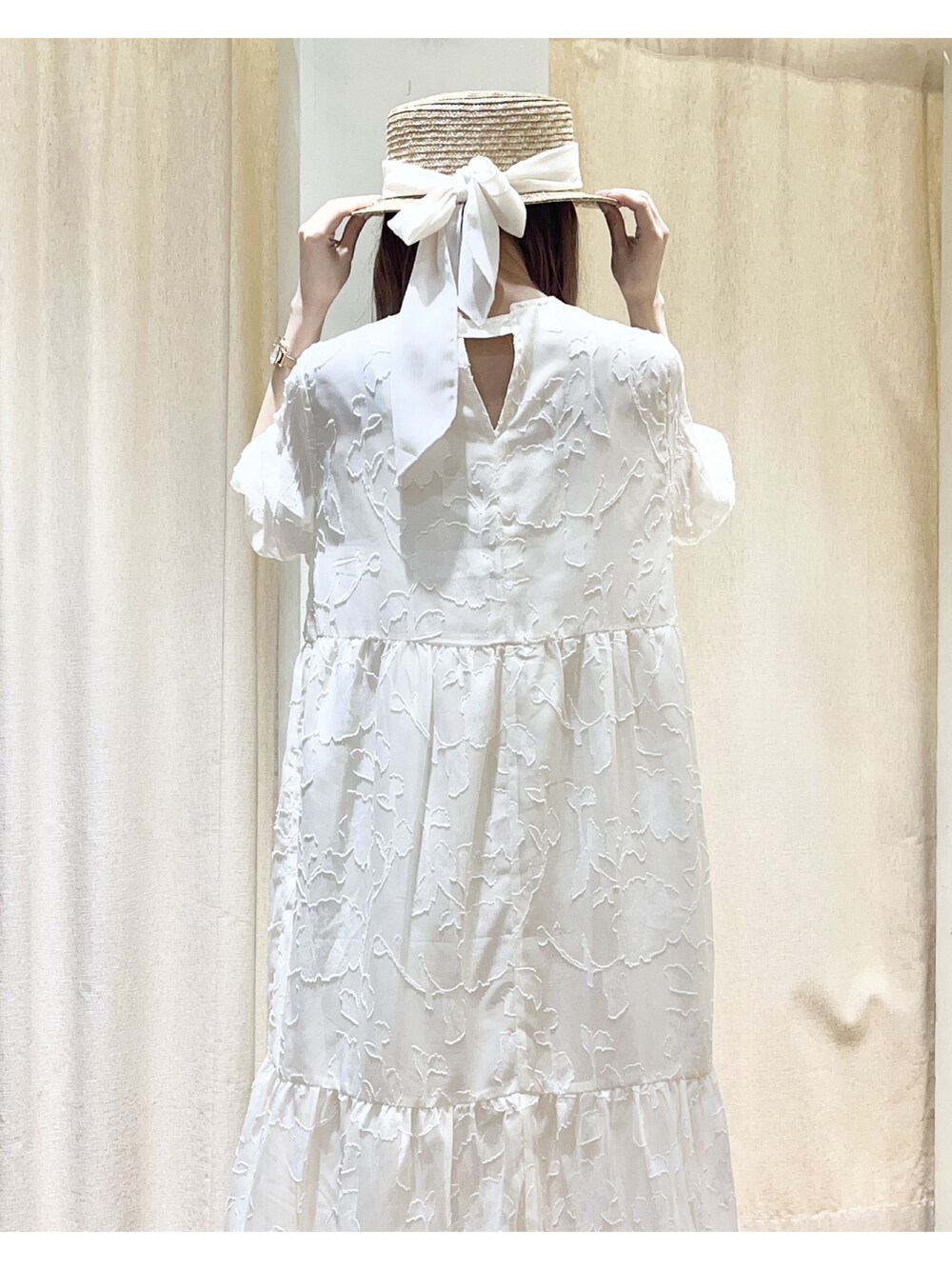 ホワイト系のワンピース、ゴールド系のバレエシューズ、ホワイト系のハットを着用したレディースの春コーディネートの2枚目の写真