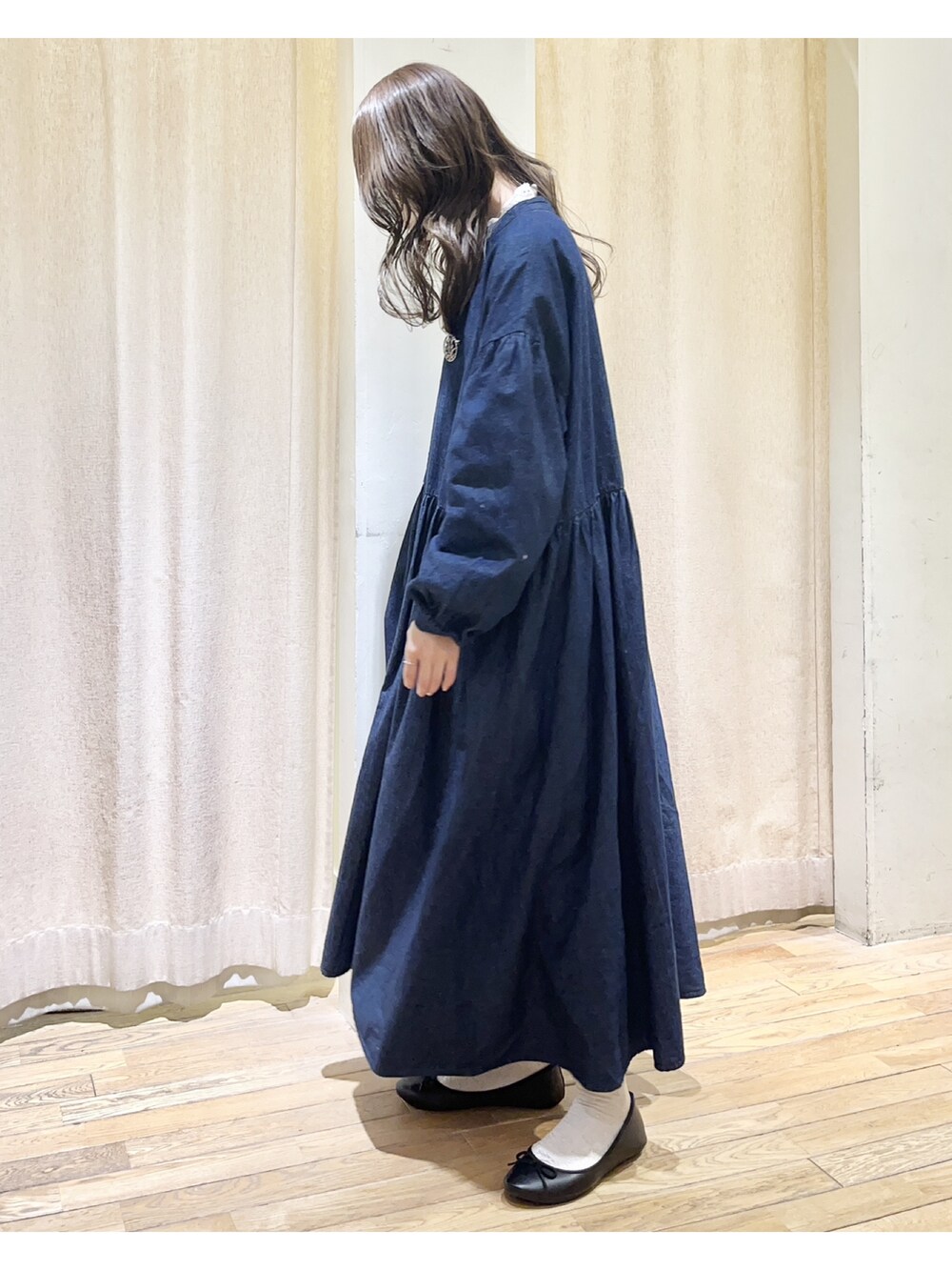 ブルー系のワンピース、ホワイト系のシャツ/ブラウス、ブラック系のハンドバッグを着用したレディースの冬コーディネートの2枚目の写真