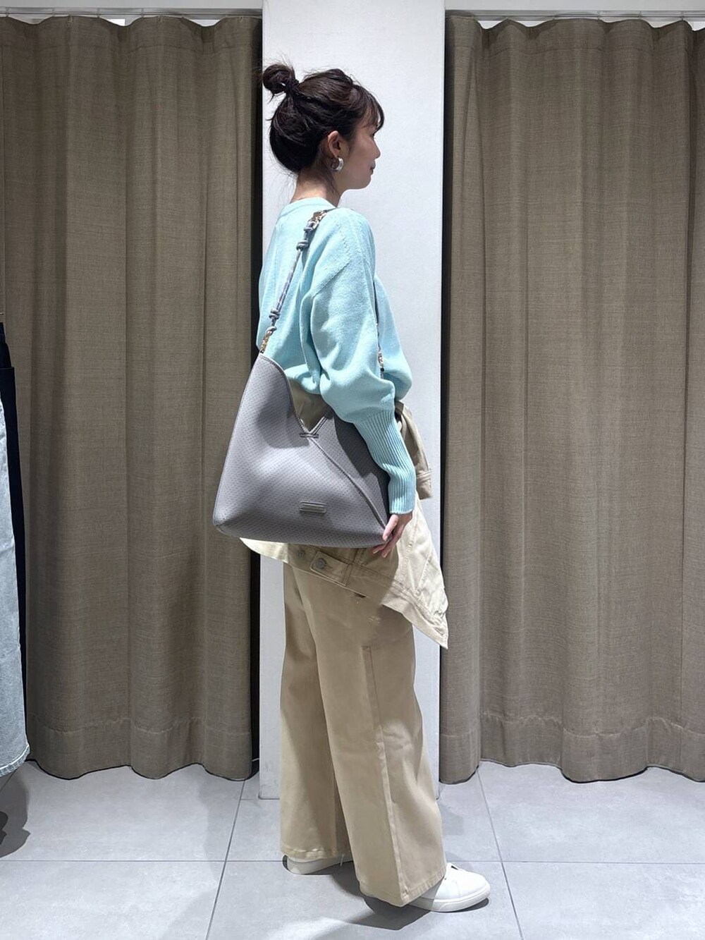 ブルー系のニット/セーター、ベージュ系のデニムパンツ、ベージュ系のデニムジャケットを着用したレディースの冬コーディネートの2枚目の写真