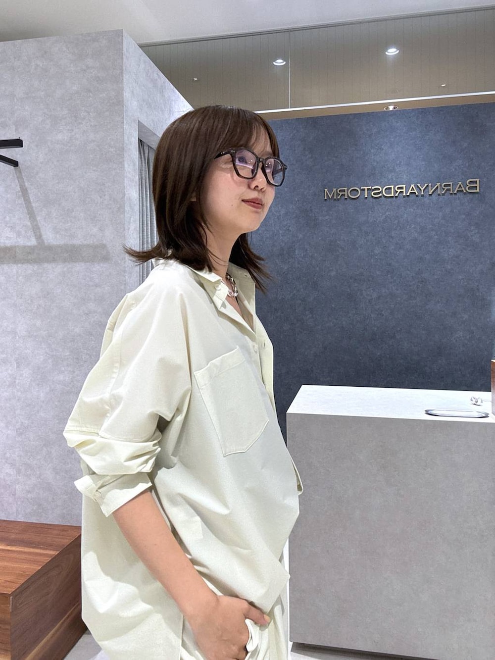 ブラック系のパンプス、ブラック系のトートバッグ、ホワイト系のシャツ/ブラウスを着用したレディースの夏コーディネートの4枚目の写真