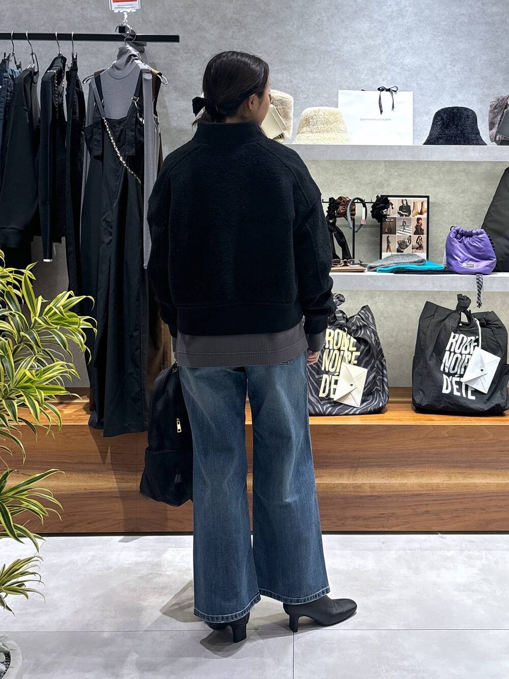 ブラック系のバックパック/リュック、ブラック系のブルゾン、ブルー系のデニムパンツを着用したレディースの冬コーディネートの4枚目の写真