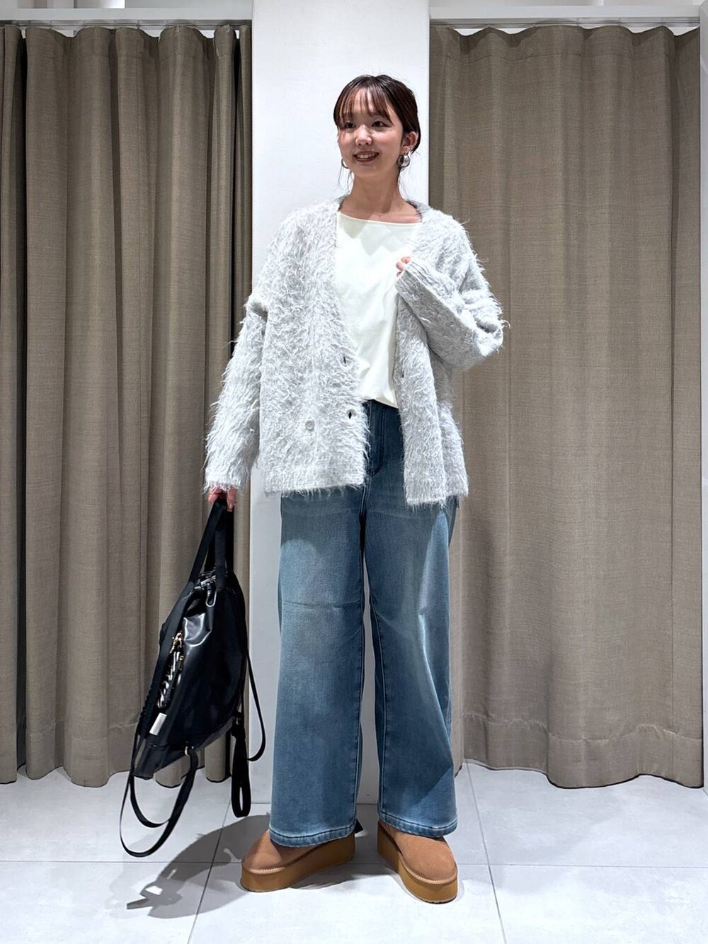 ブラック系のバックパック/リュック、ブルー系のデニムパンツ、イエロー系のブーツを着用したレディースの秋コーディネートの6枚目の写真