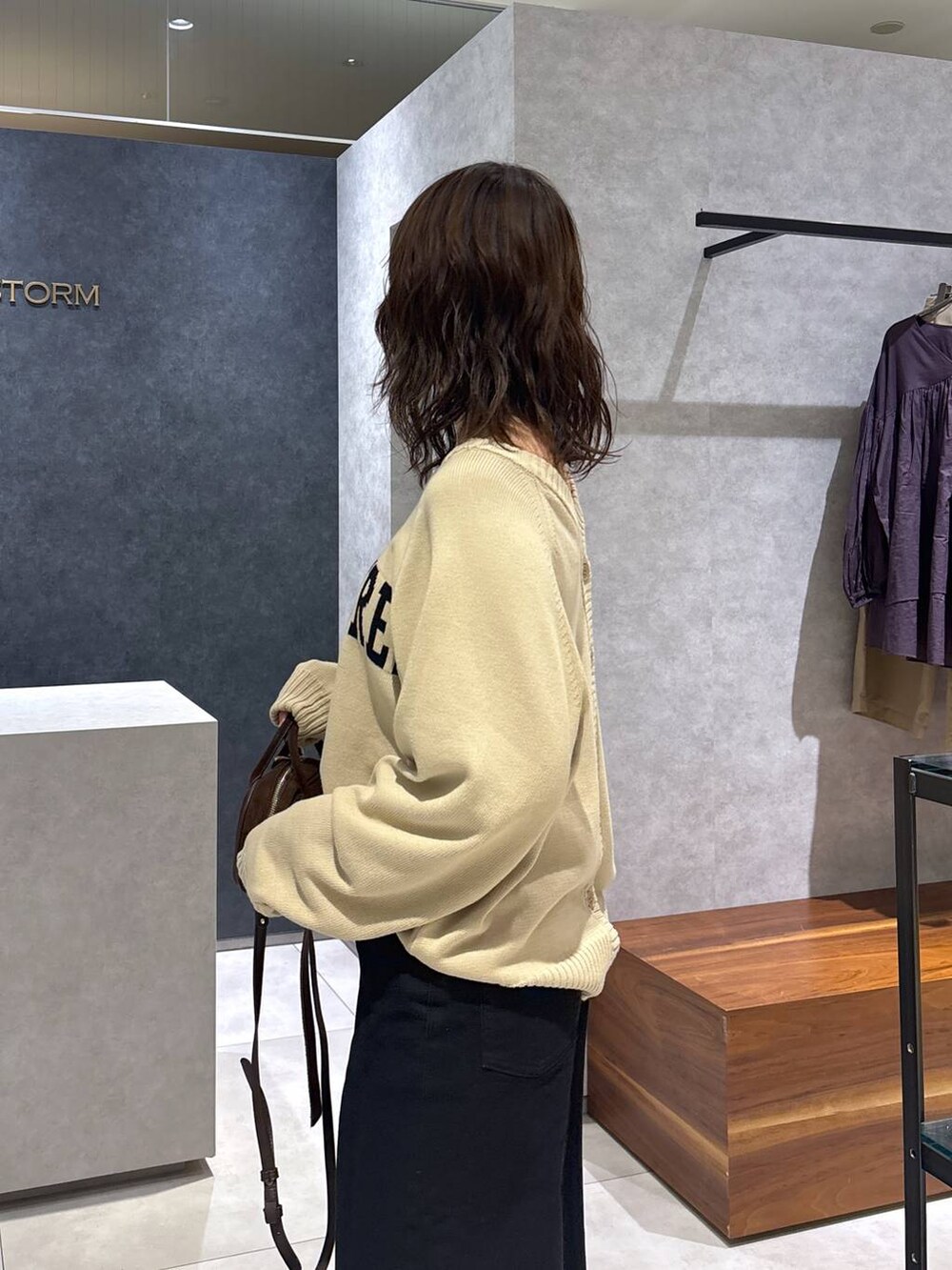ブラック系のデニムパンツ、ベージュ系のカーディガン/ボレロ、ブラウン系のショルダーバッグを着用したレディースの夏コーディネートの4枚目の写真