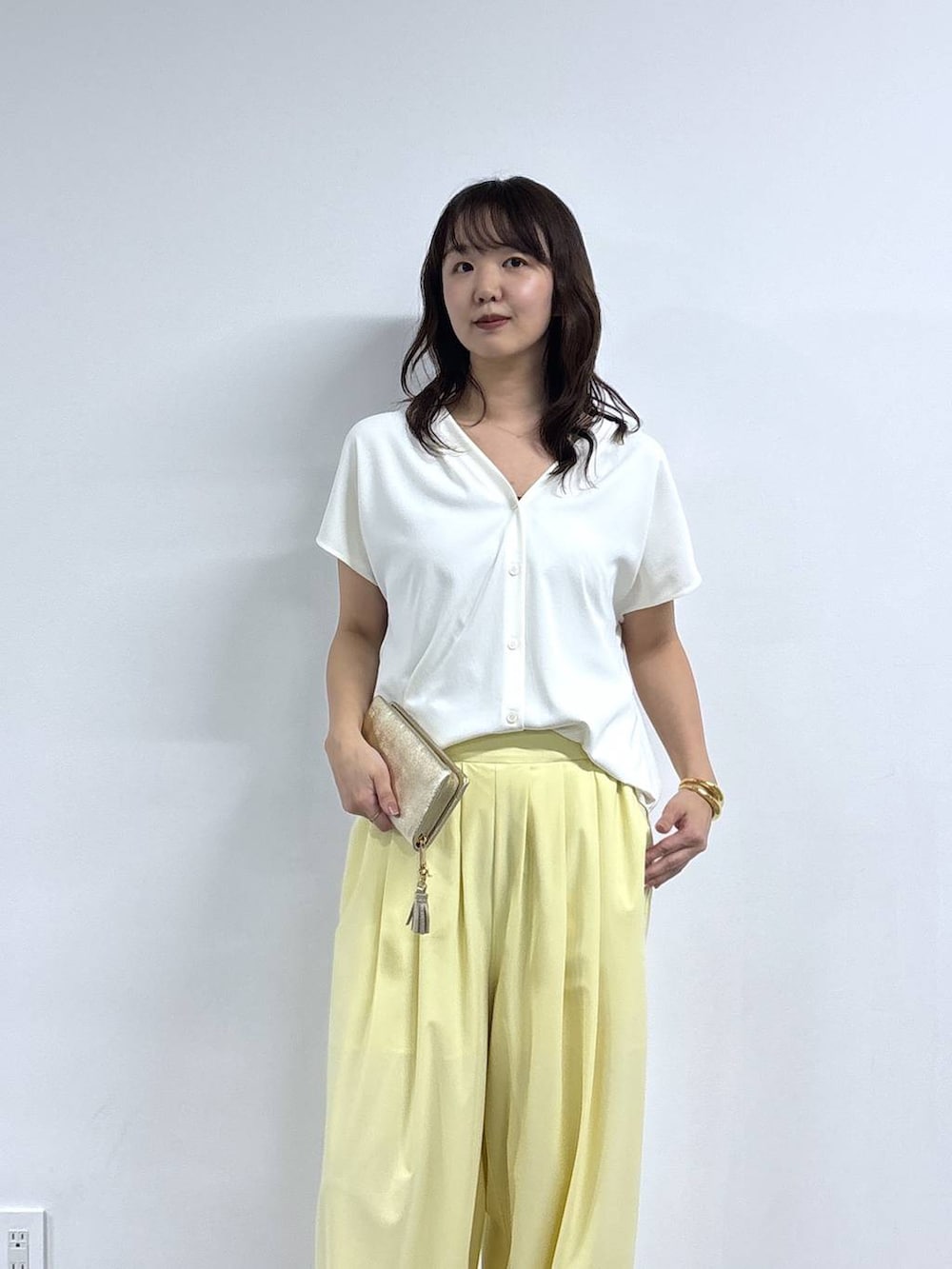 ホワイト系のシャツ/ブラウス、イエロー系のその他パンツ、ブラウン系のパンプスを着用したレディースの春コーディネートの2枚目の写真