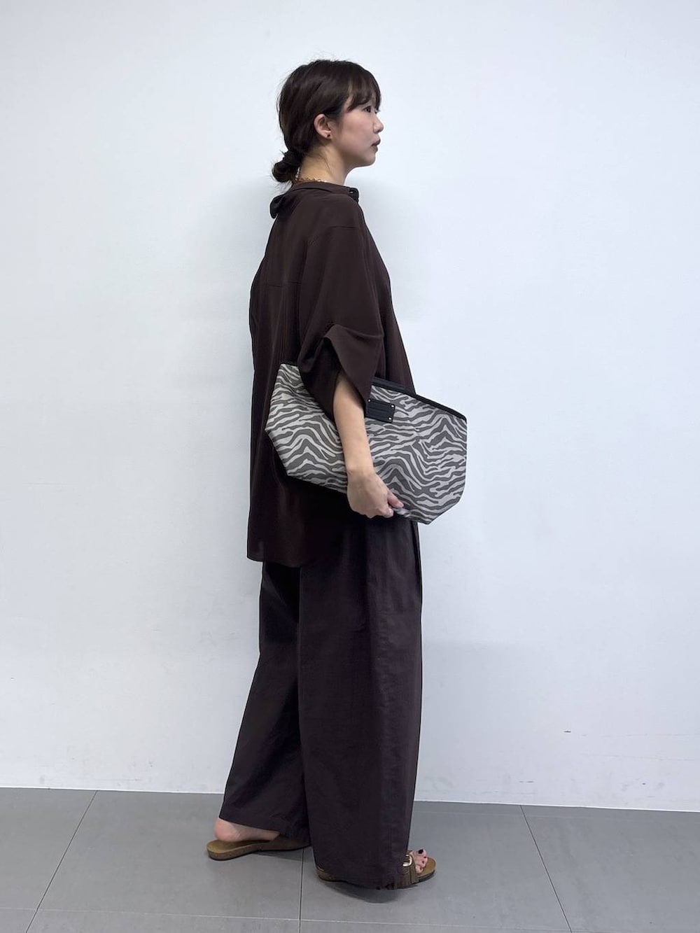 ブラウン系のその他パンツ、グレー系のトートバッグ、ブラウン系のサンダルを着用したレディースの春コーディネートの3枚目の写真