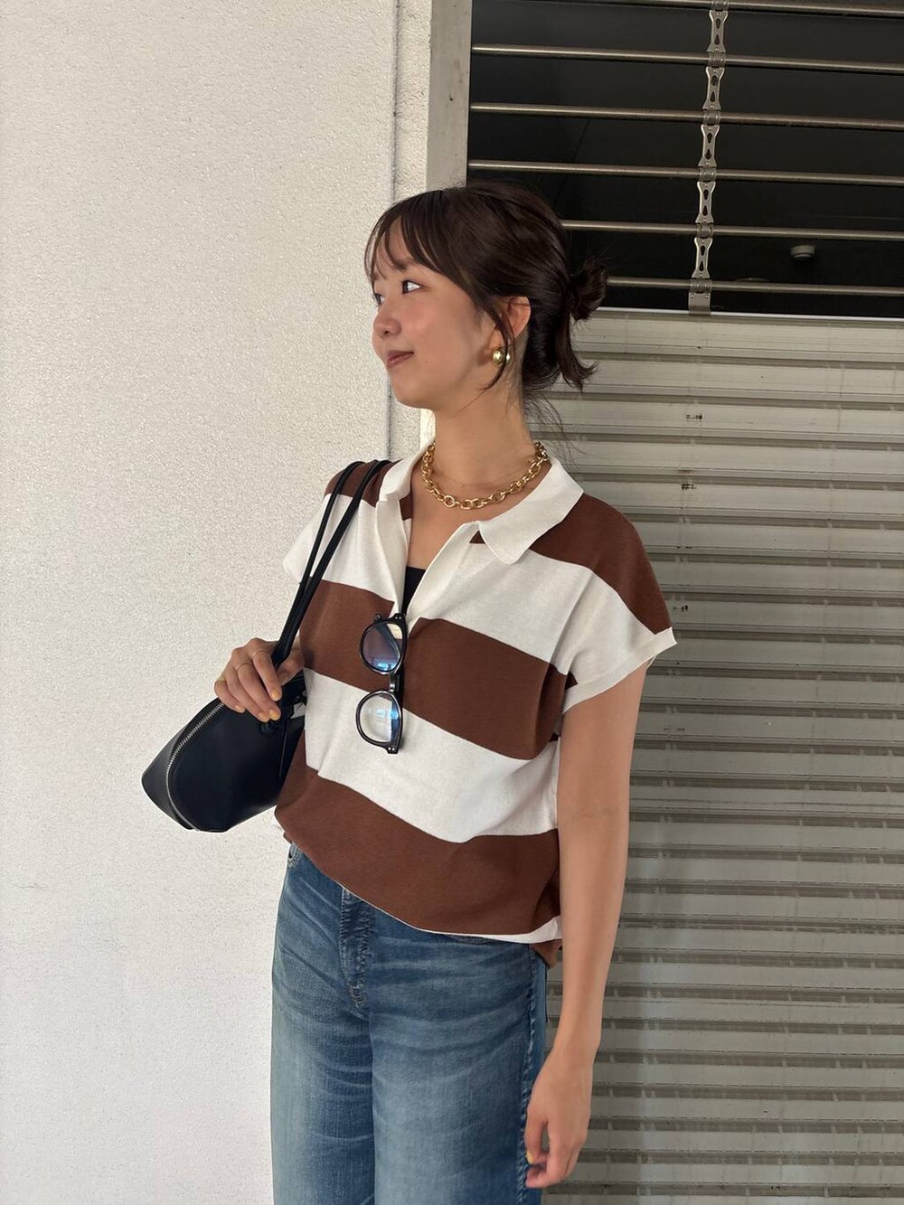 ブルー系のデニムパンツ、ブラック系のトートバッグ、イエロー系のニット/セーターを着用したレディースの夏コーディネートの6枚目の写真